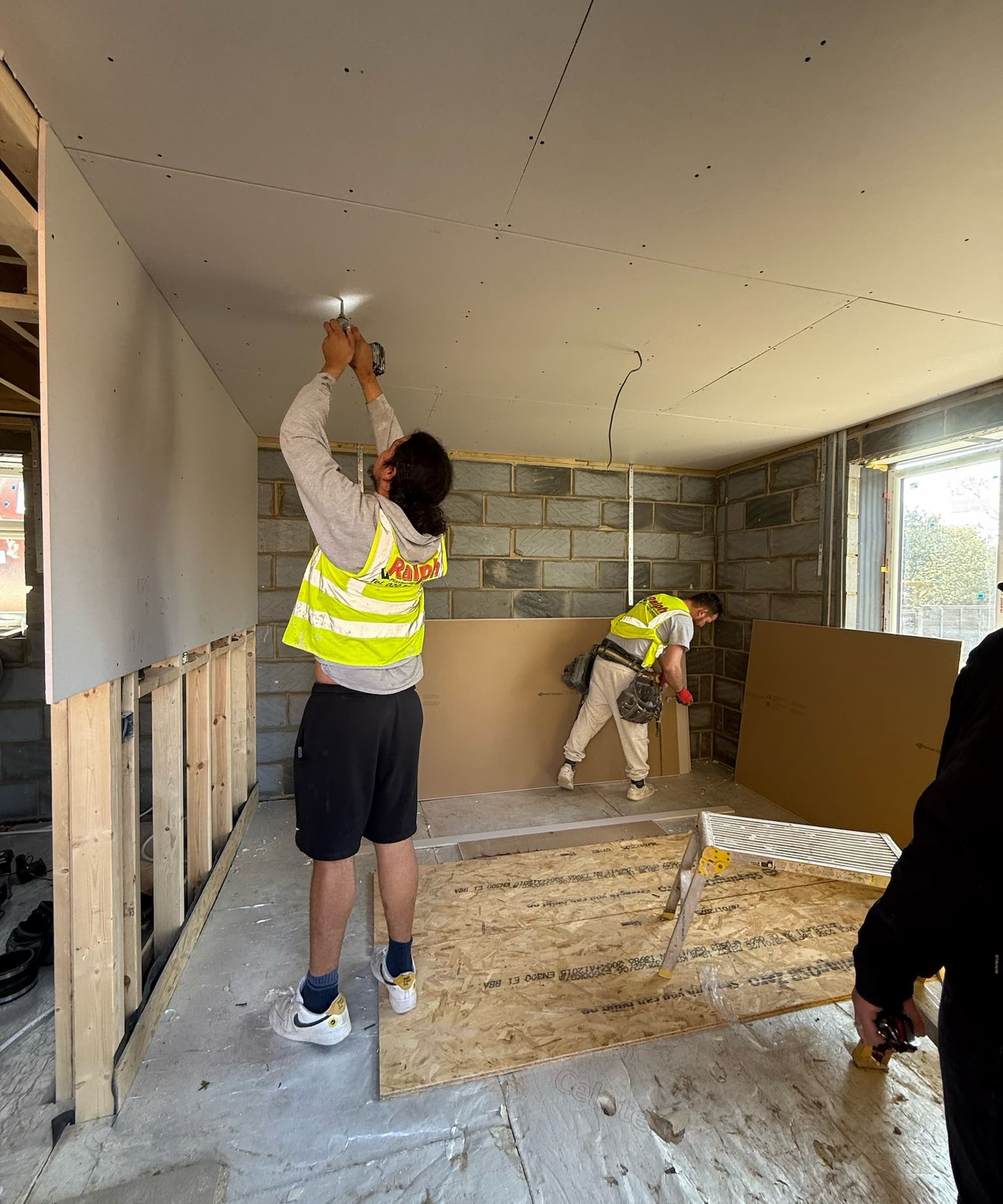 Builders putting in light fittings into an extension