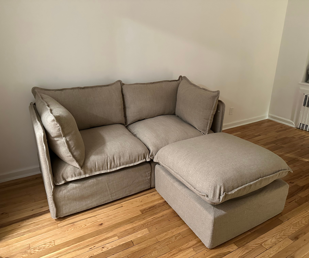 a tan couch and an ottoman in a room