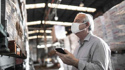photo of older man with mask working in warehouse
