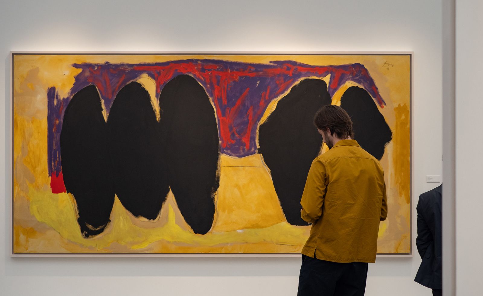 man in front of painting