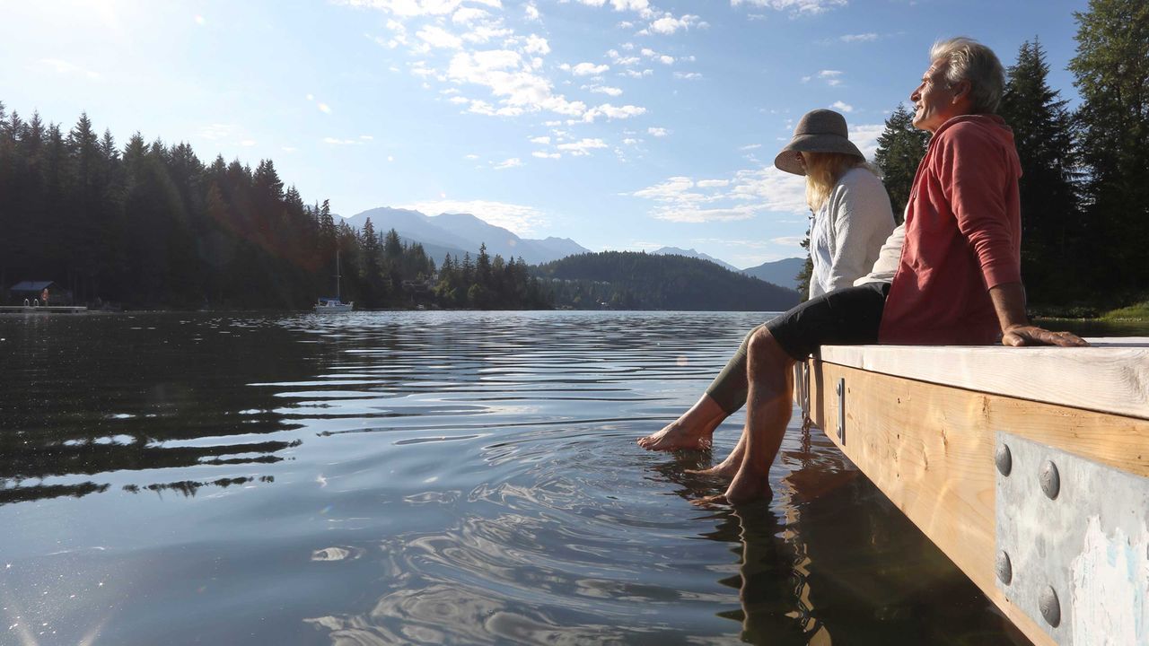 Couple sitting on a pier with their feet in the water