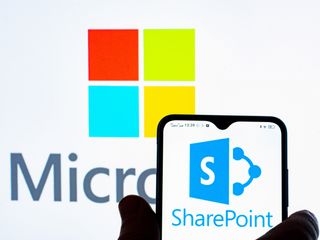 Microsoft SharePoint logo displayed on a smartphone and Microsoft logo in the background