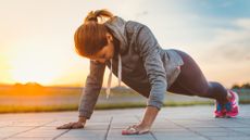 A woman performing a push-up outside