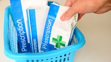 Three bags of prescriptions in a blue basket