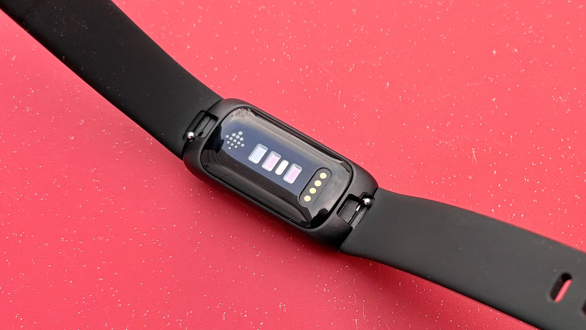 Rear of the Fitbit Inspire 3 up-close on a red background; the new Fitbit Air could cost the same as the Inspire 3 ($99)