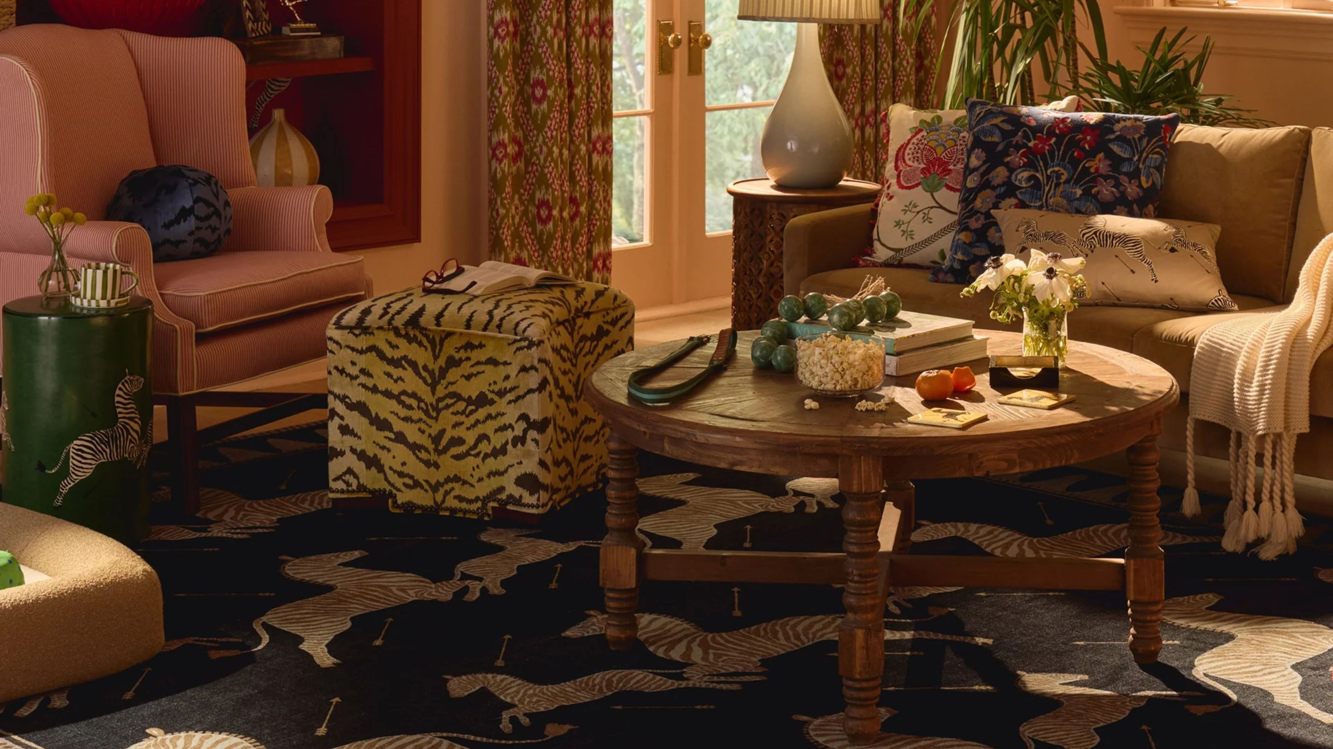 Eclectic, pattern-filled living room featuring a tiger print ottoman, wooden coffee table, and zebra motif area rug