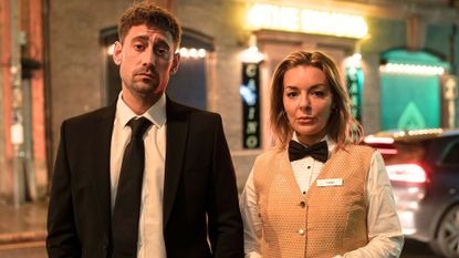 Michael Socha and Sheridan Smith stand outside a casino in their uniforms