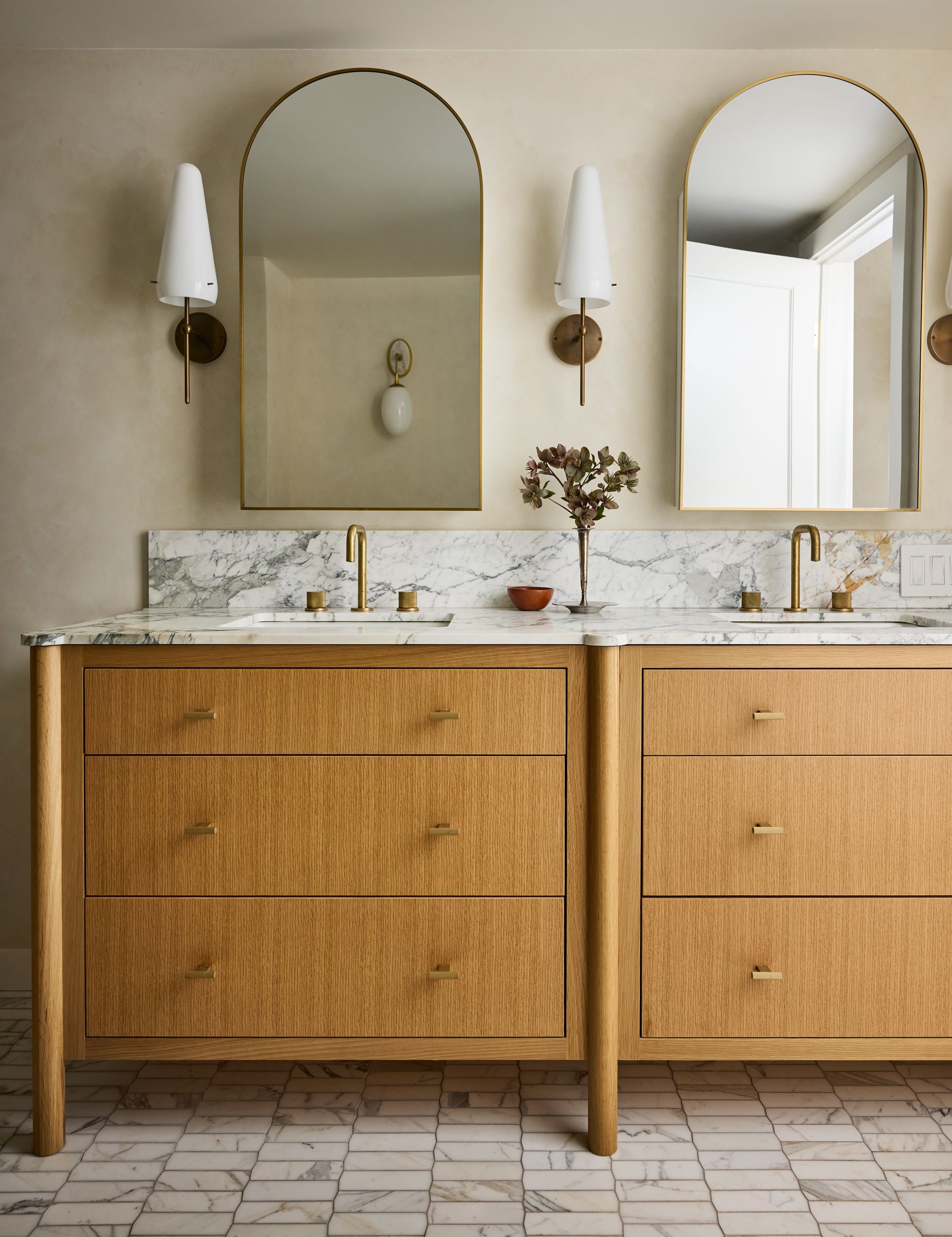 A double vanity with wall lights framing them either side