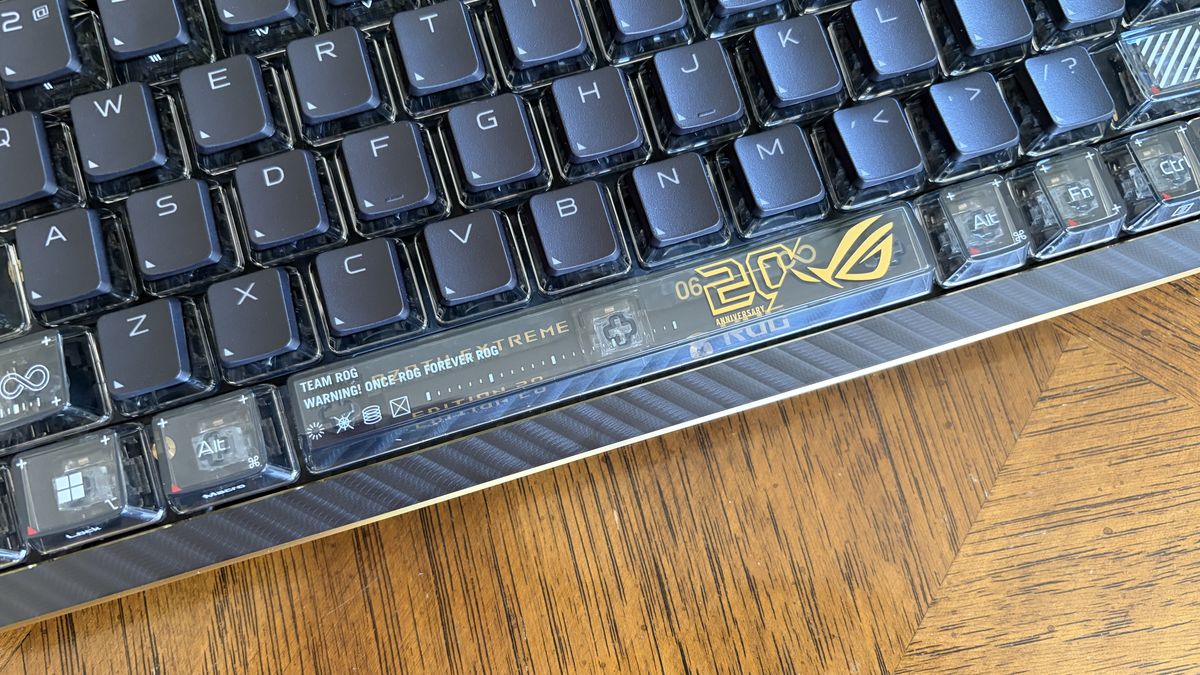 Close-up of an ASUS ROG Azoth Extreme Edition 20 mechanical keyboard with transparent keycaps and a "20th Anniversary" decal.