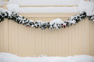 snow covered festive garland on a fence