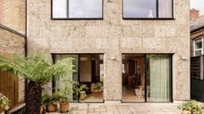 exterior of house clad in cork with terrace garden and plants