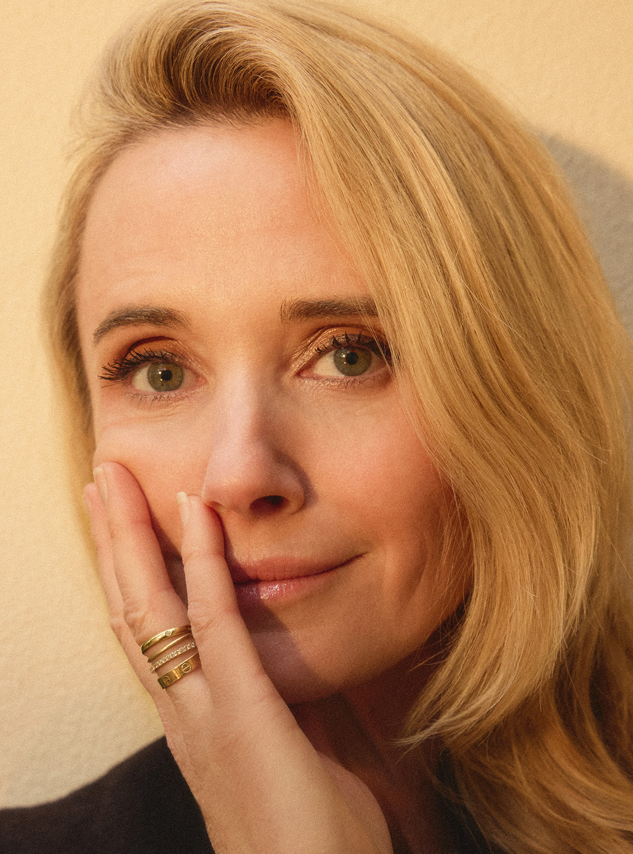 Jennifer Siebel Newsom holds one hand up to her face in a close up photograph by Marie Claire