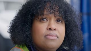 Natasha Rothwell looking up at the camera with an unreadable expression in How To Die Alone