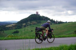 Image shows Anna cycling towards Banská Štiavnica