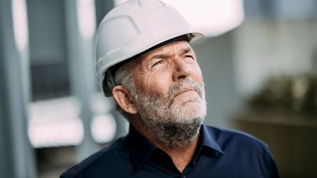 Portrait of mature engineer in a white hard hat 