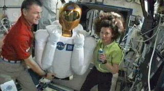 NASA astronaut Cady Coleman (right) and Italian astronaut Paolo Nespoli proudly display the newest resident of the International Space Station, the humanoid Robonaut 2 robot, to cameras on March 15, 2011. 