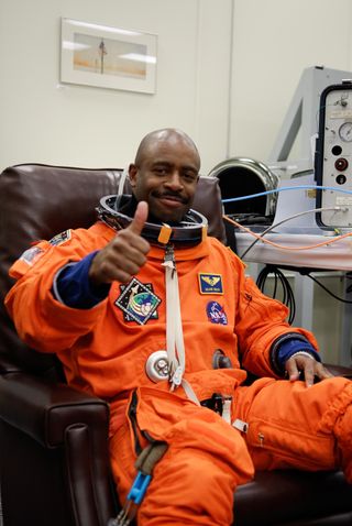 Mission Specialist Leland Melvin signals that it's go time for the launch of space shuttle Atlantis on the STS-122 mission while he dons the launch and entry suit.