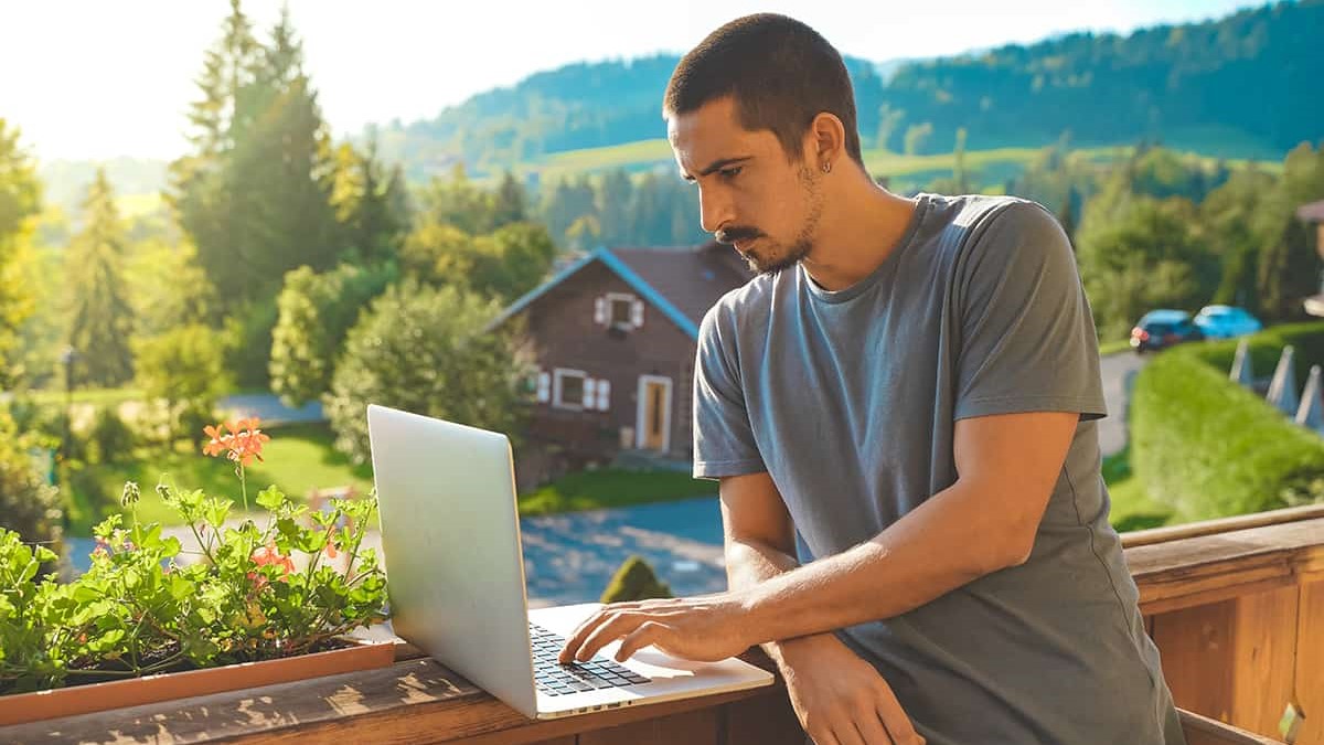 Man using a laptop in the countryside