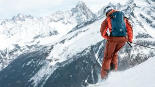 A skier wearing a blue backpack in Chamonix