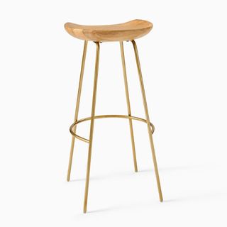 A wooden bar stool with gold steel legs for sustainable furniture brands.