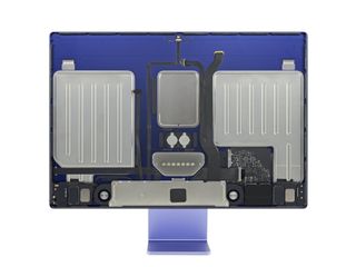 iFixit's teardown of the Apple iMac 2021. With the screen removed, the internal components are now visible. The logic board sits towards the bottom while metal plates take up the rest of the device.