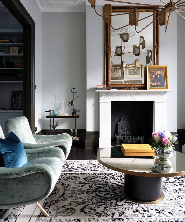 Modern living room with fireplace, white walls and green chairs