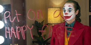 Joker Arthur looks at a message on his dressing room mirror