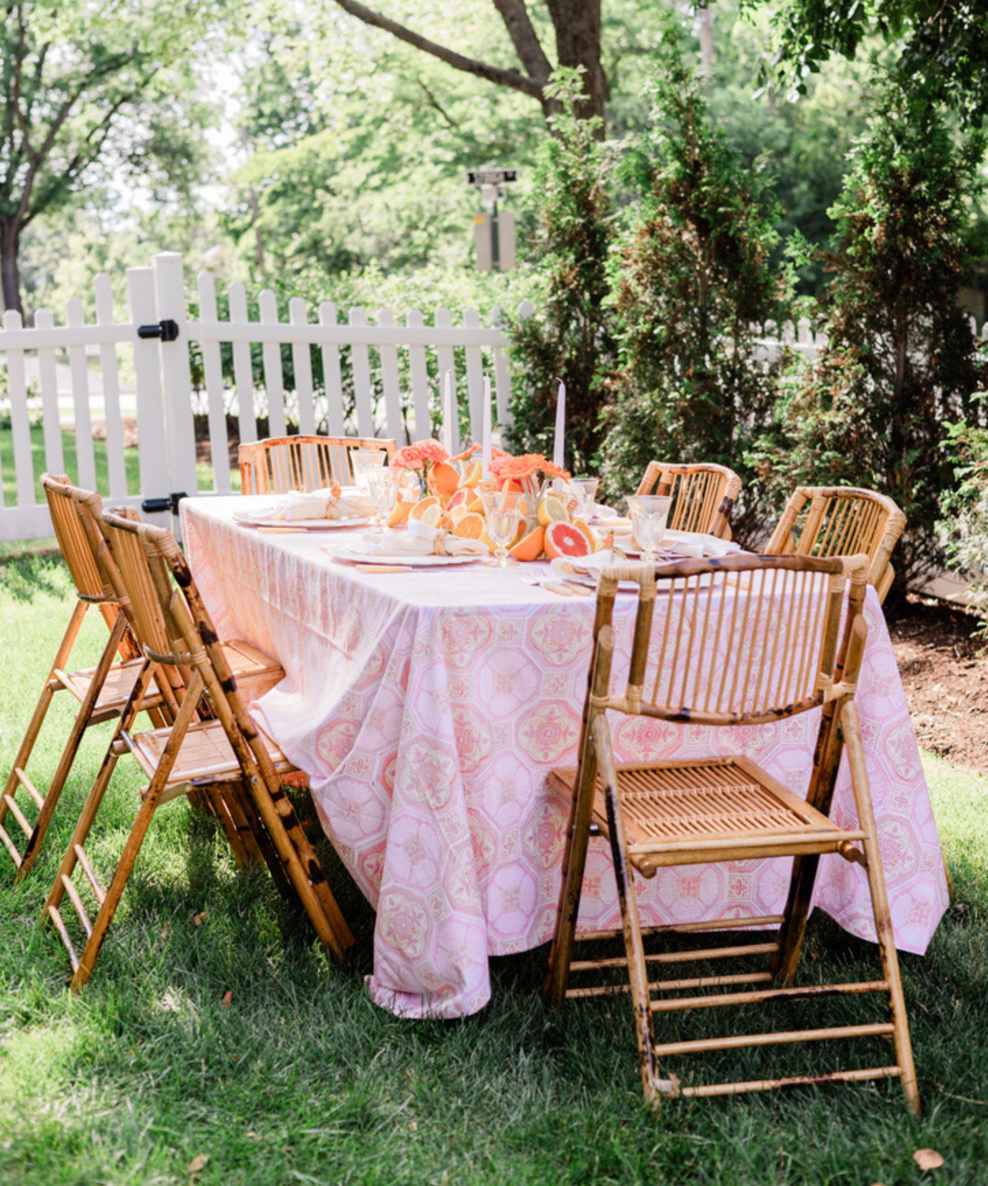 Table set outdoors with fruit centerpiece and bamboo chairs