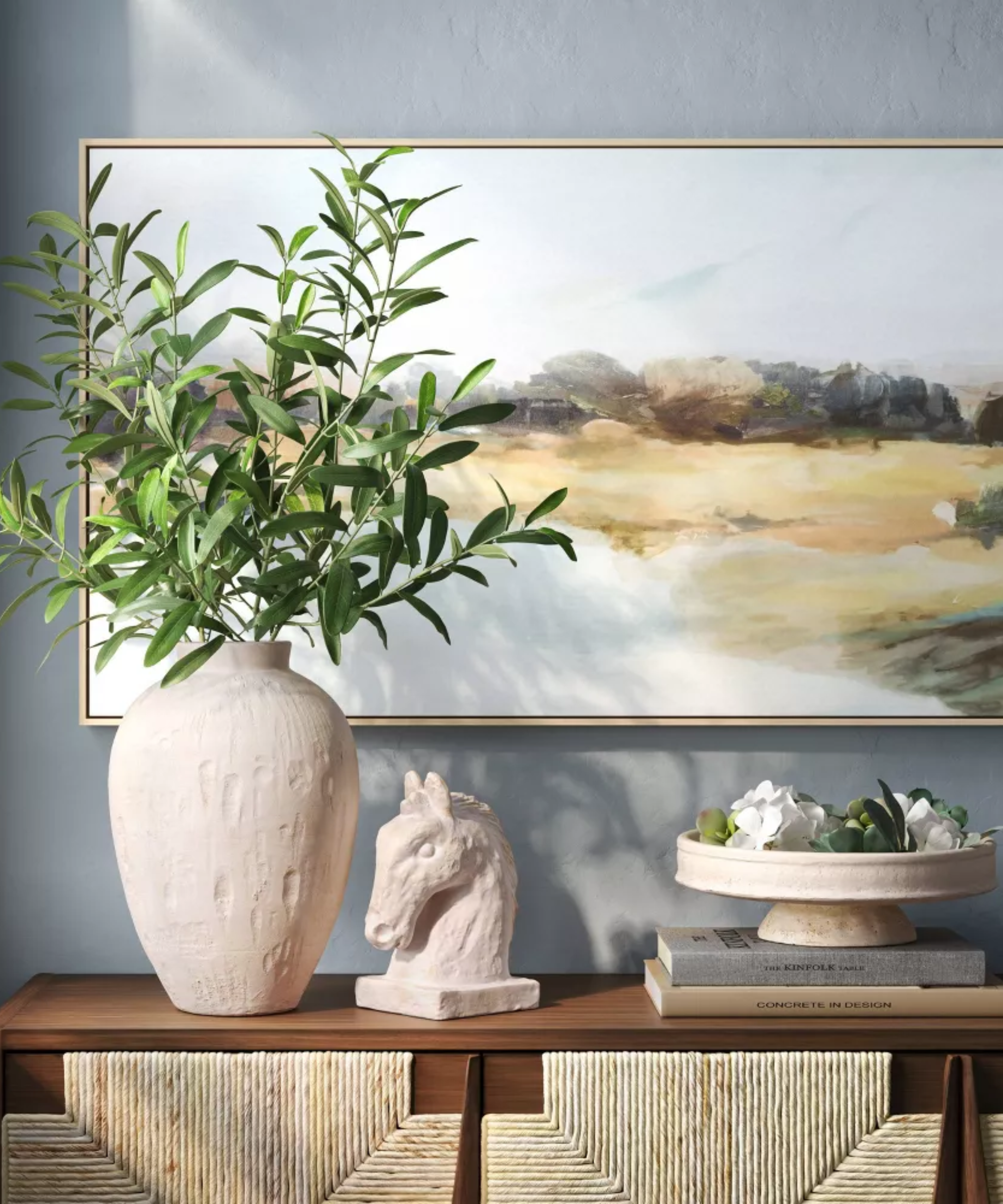 a credenza with a large vase with branches in it, a horse head sculpture, and a pedestal bowl