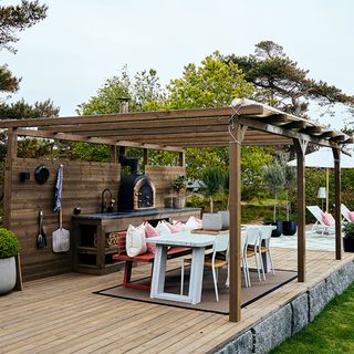 outdoor kitchen dining table with chair and chimney pergola