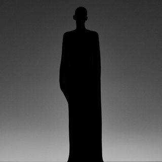 Silhouette of man in black long outfit