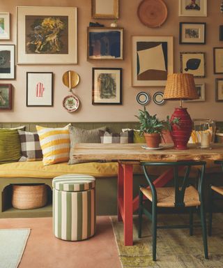 kitchen with artfilled pink wall and inbilt green bench with storage units under