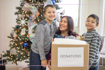 Mother and two sons carrying a box of donations.