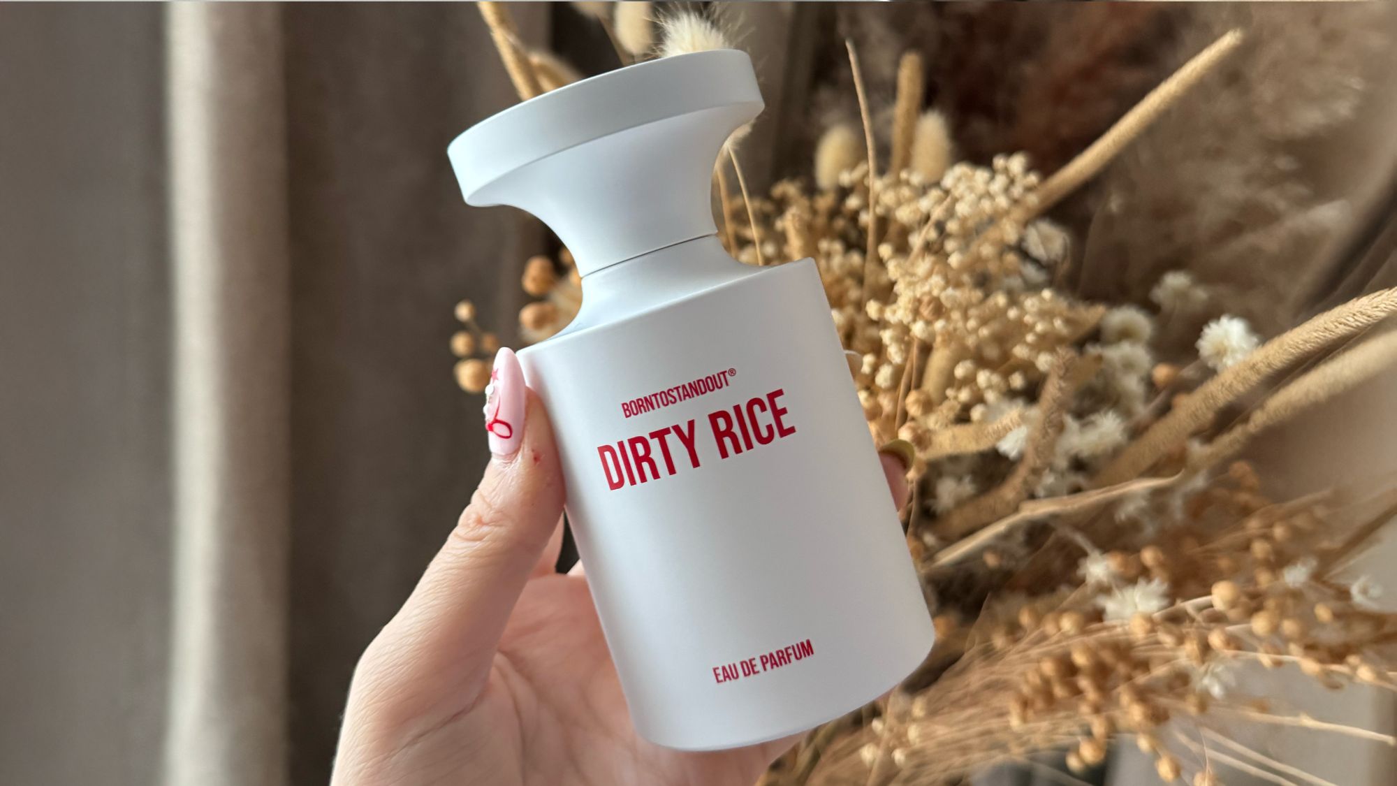 An image showing a person holding the Dirty Rice eau de parfum by BornToStandout