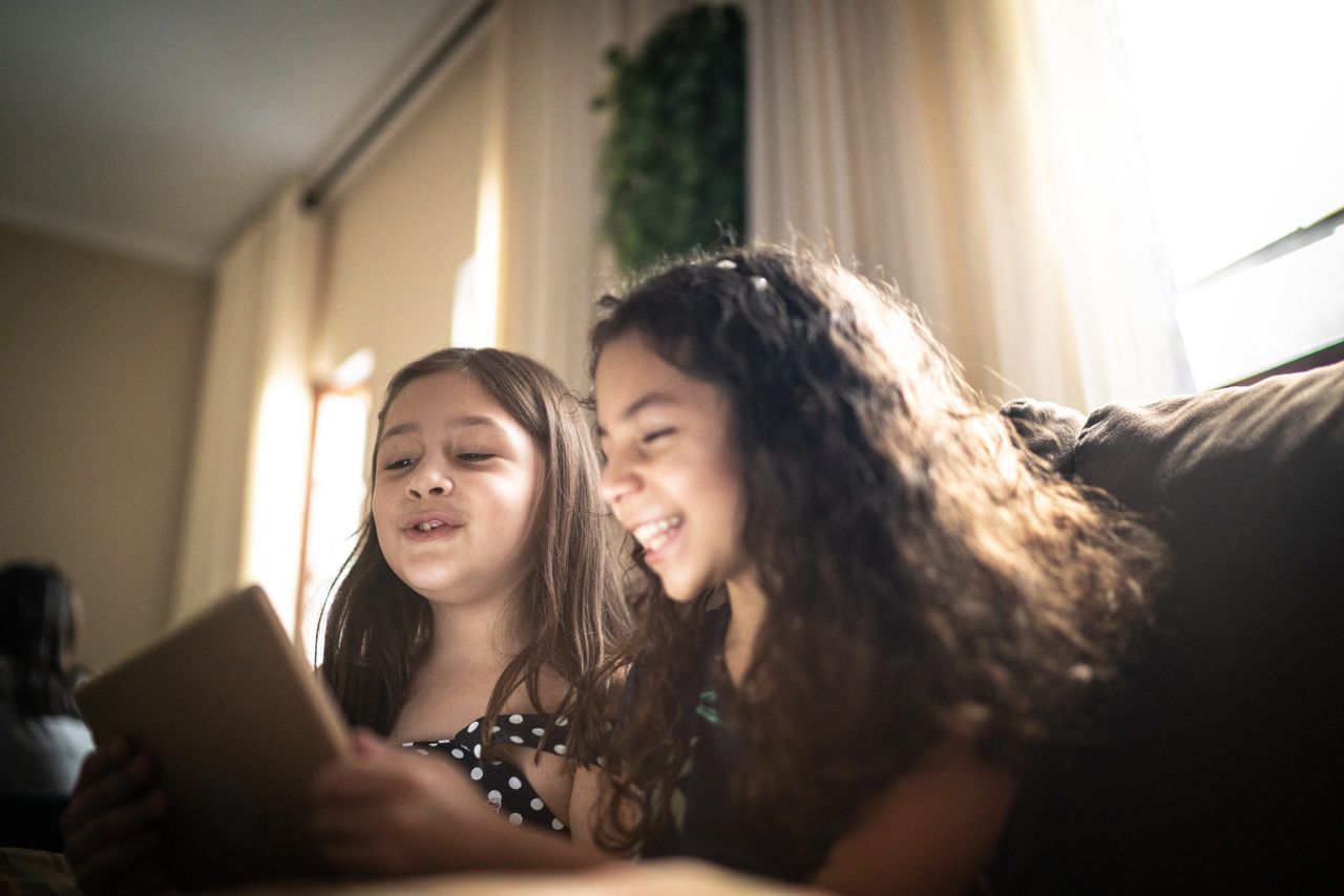 Two girls smiling while playing Zoom games for kids