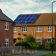 Solar panel on the roof of a red brick house