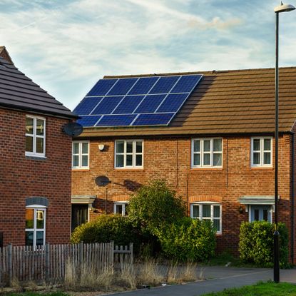 Solar panel on the roof of a red brick house