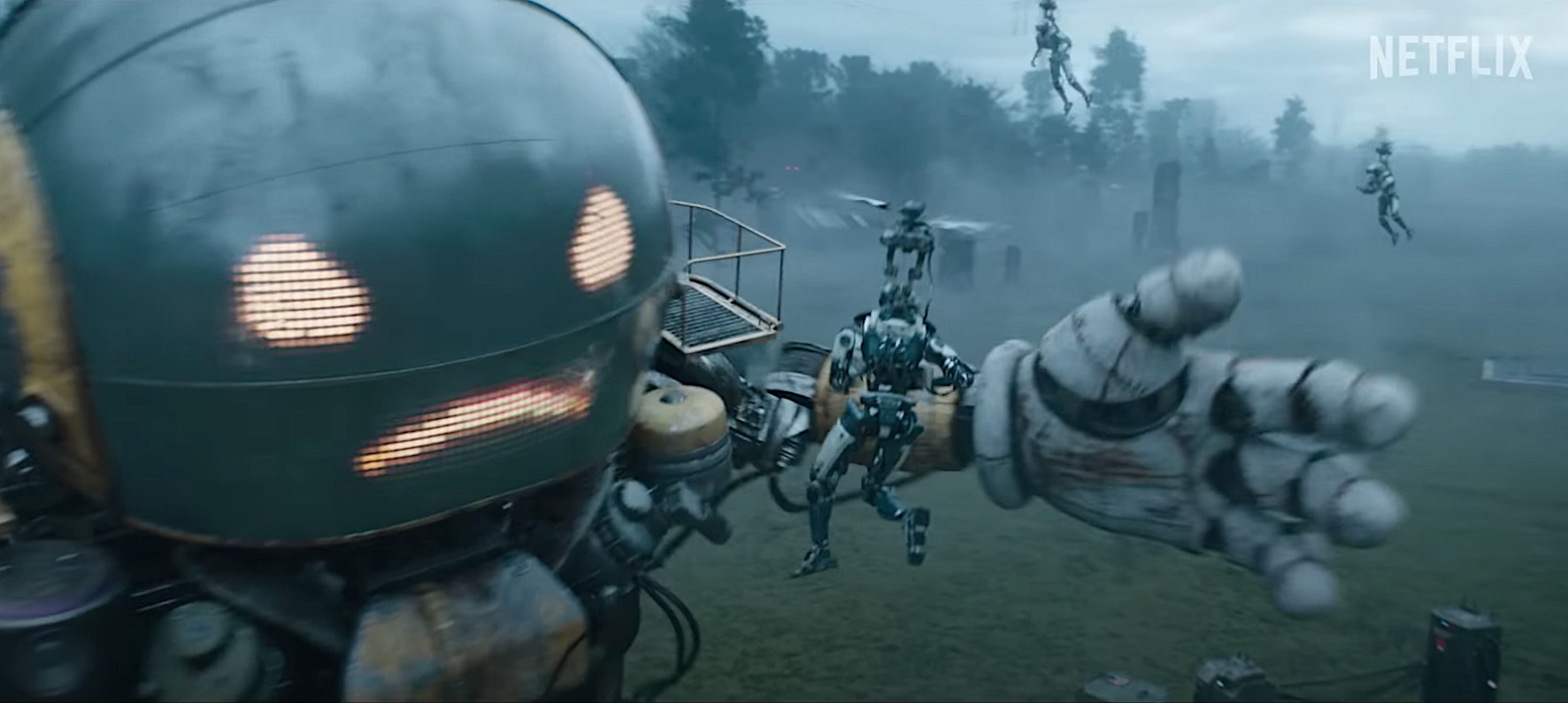 A huge robot fends off an attack by flying humans