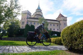 Image shows Stefan cycling towards the Castle of Spirits (Bojnice Castle) in Slovakia
