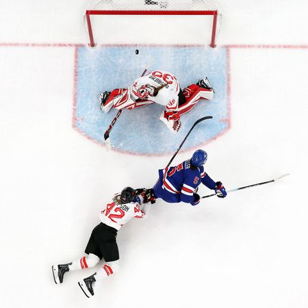 MILAN, ITALY - FEBRUARY 19: (EDITOR'S NOTE: Image was captured using a remote camera positioned above the field of play.) Megan Keller #5 of Team United States scores the game winning goal in overtime against Claire Thompson #42 and Ann-Renee Desbiens #35 of Team Canada to win the gold medal during the Women's Gold Medal match between the United States and Canada on day 13 of the Milano Cortina 2026 Winter Olympic games at Milano Santagiulia Ice Hockey Arena on February 19, 2026 in Milan, Italy.
