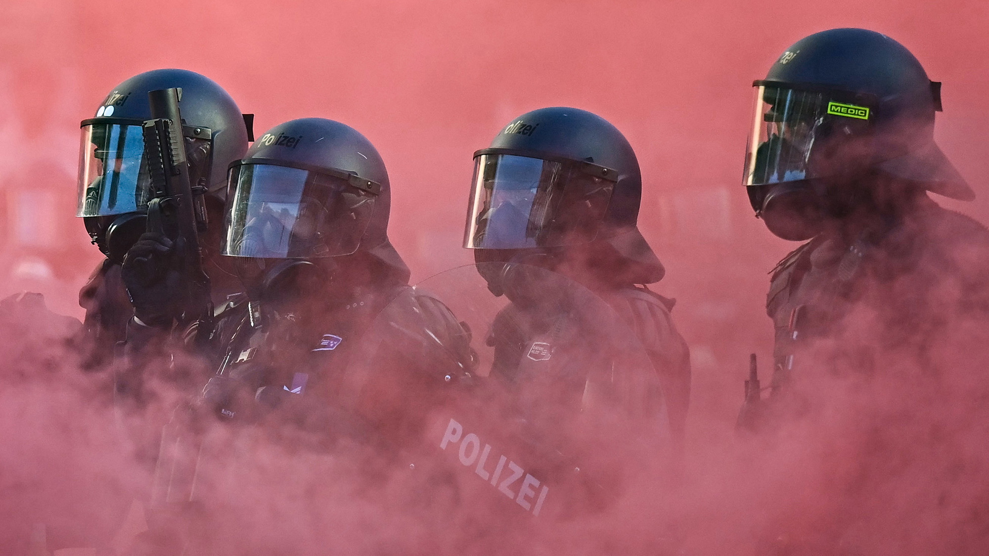 Armoured police officers are seen in a cloud of red smoke during a rally of a coalition against fascism and imperialism a day ahead of the G7 summit's start, in Geneva, Switzerland