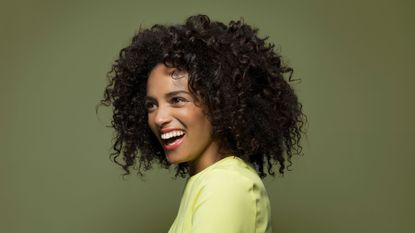 picture of Amerley Ollennu with curly hair smiling and holding a cup of tea