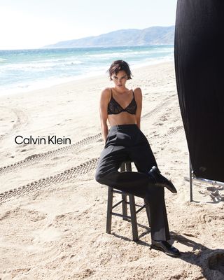 Kendall Jenner modeling for Calvin Klein on the beach in a lace bralette and trousers