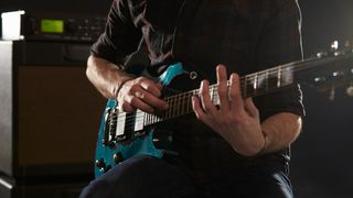 A guitarist taps their way along the fretboard