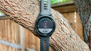 Running workout screen on the Garmin Forerunner 255 in front of a tree