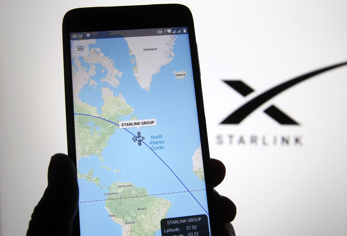 Starlink tracker on phone with Starlink logo in background
