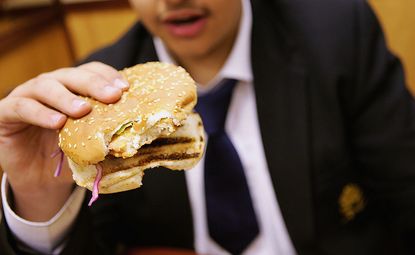 Teen holding hamburger.