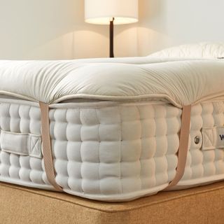 Woolroom Deluxe Wool Mattress Topper strapped onto a mattress