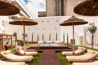 hotel pool with loungers and sun umbrellas