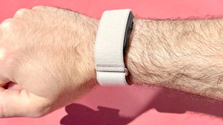 Close-up of the Garmin Cirqa on the writer's wrist against a red background